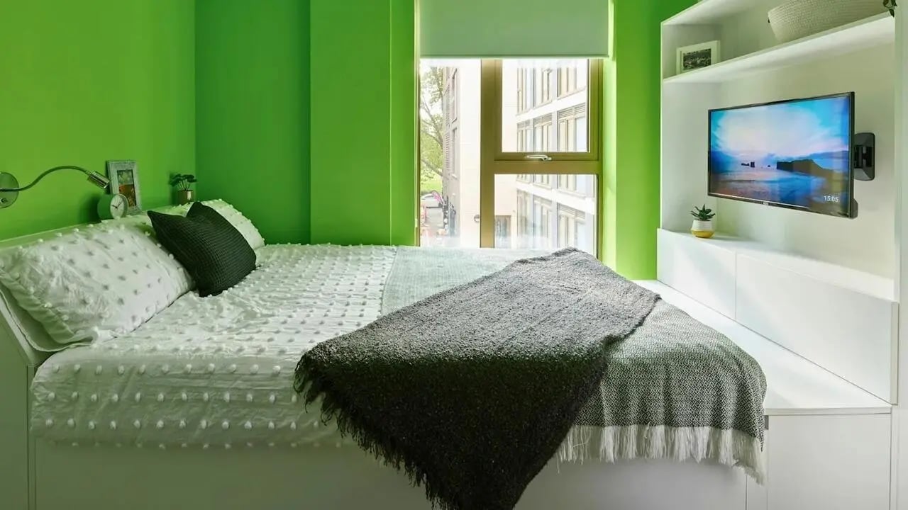 Bed with pillows and throw blanket bedroom at View Studios in London Student Accommodation