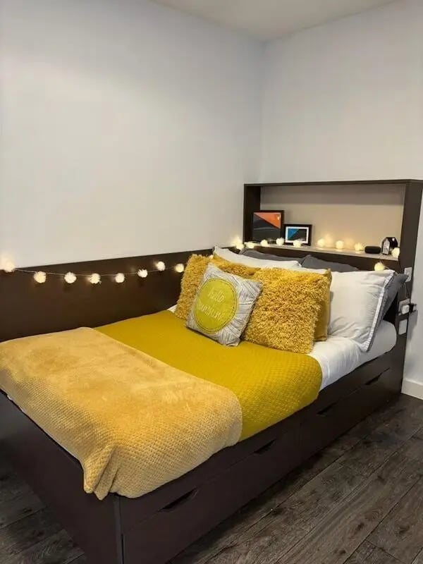 Bed with yellow bedding and fairy lights bedroom at Cornerhouse in Sheffield Student Accommodation