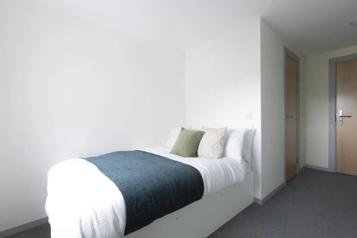 Bed with pillows and teal blanket bedroom at Bryson Court in Newcastle Upon Tyne Student Accommodation