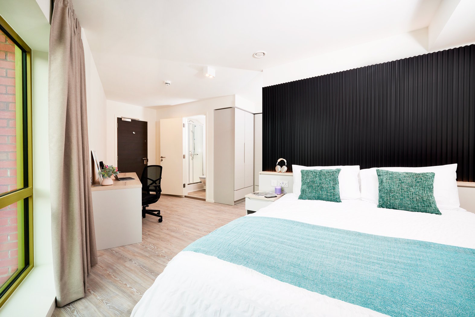 Bed desk chair and open shower room bedroom at Vita Student Bruce Street in Belfast Student Accommodation
