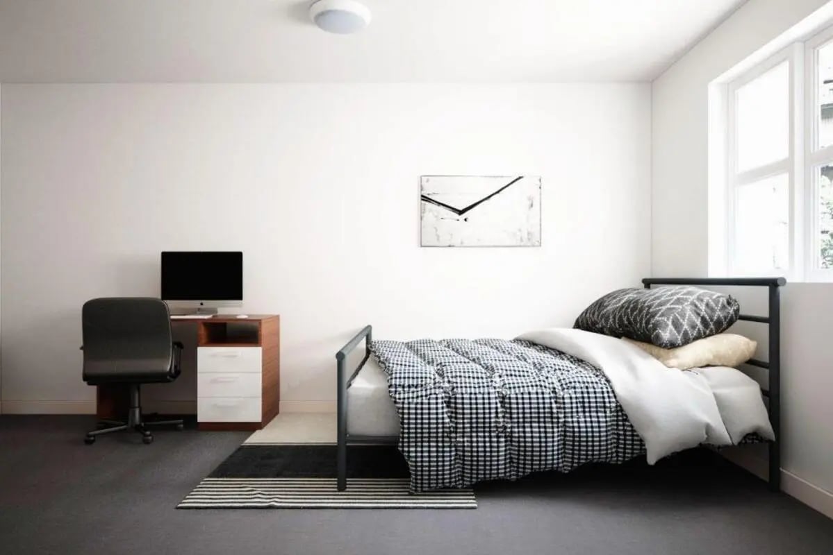 Bed with checkered bedding desk chair computer study bedroom at Moss Court in Manchester Student Accommodation