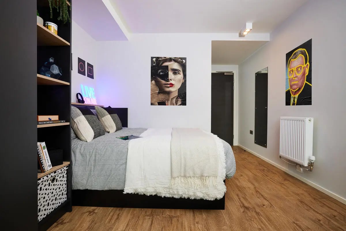 Bed pillows artwork neon sign bookshelf bedroom at Vita Student Pebble Mill in Birmingham Student Accommodation