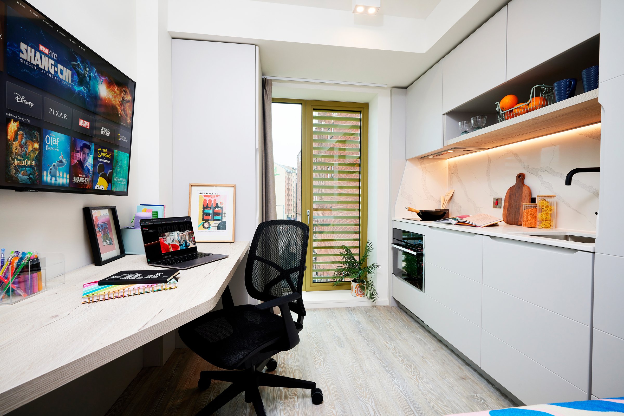 TV laptop desk chair and kitchen counter kitchenette at Vita Student Gough Street in Birmingham Student Accommodation