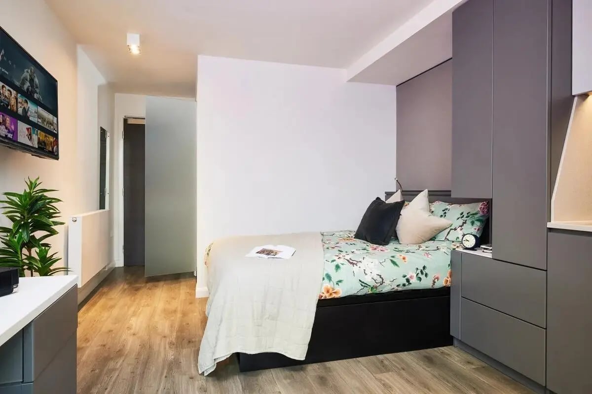 Bed with floral bedding and modern grey wardrobe bedroom at Vita Student Newcastle Strawberry Place in Newcastle Upon Tyne Student Accommodation