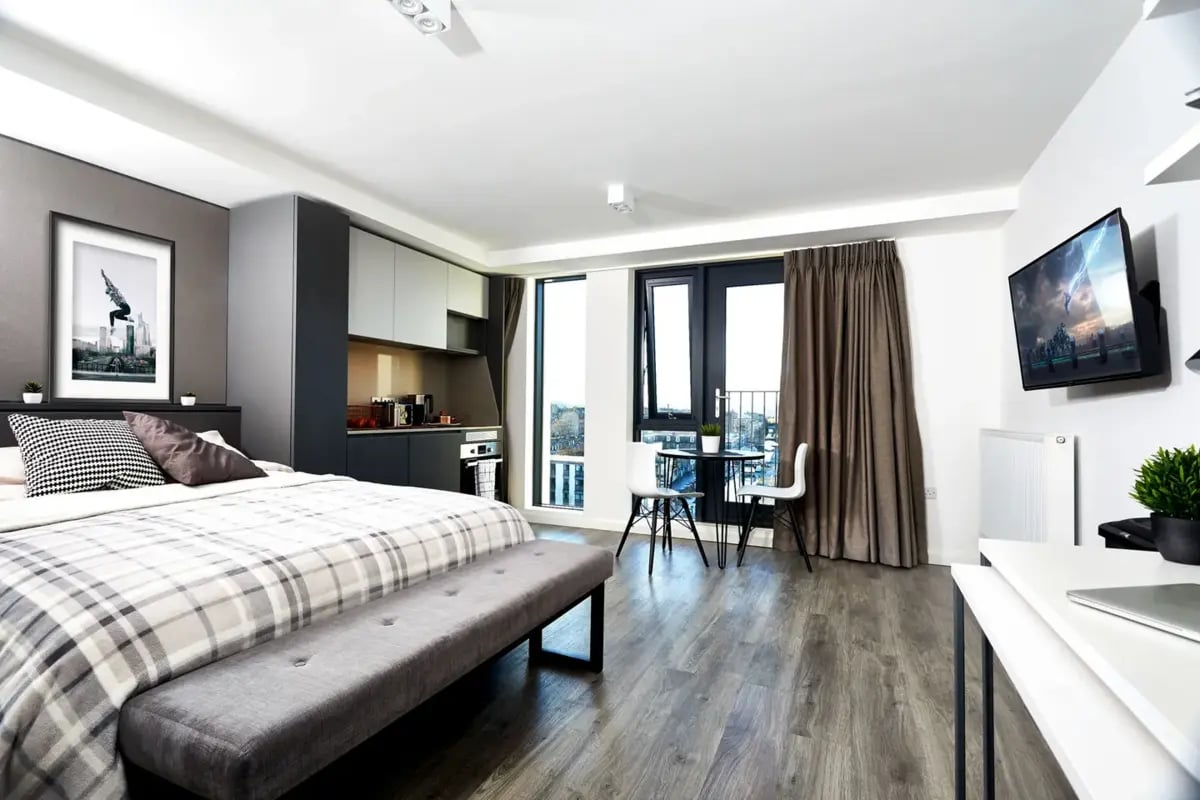 Bed, bench, small table, kitchen, TV bedroom at Vita Student Fountainbridge - Edinburgh in Edinburgh Student Accommodation