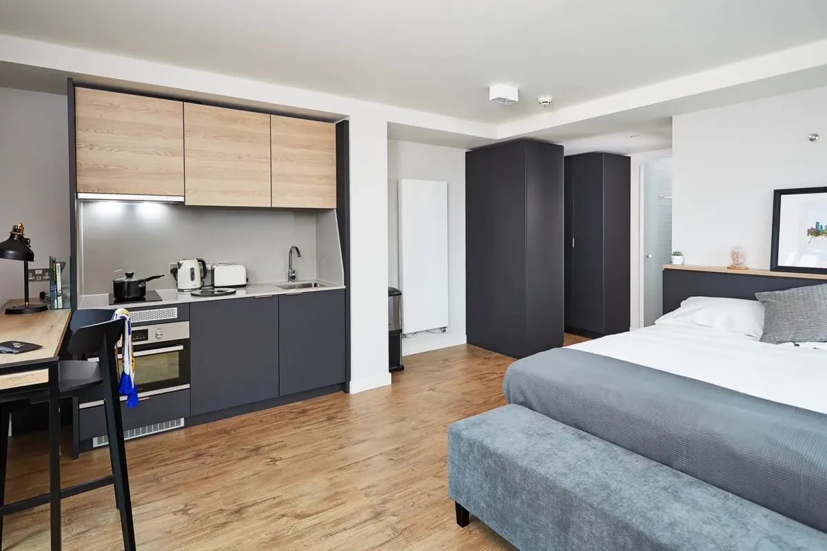 Kitchen area and bed with bench living room at Vita Student St.Albans in Leeds Student Accommodation