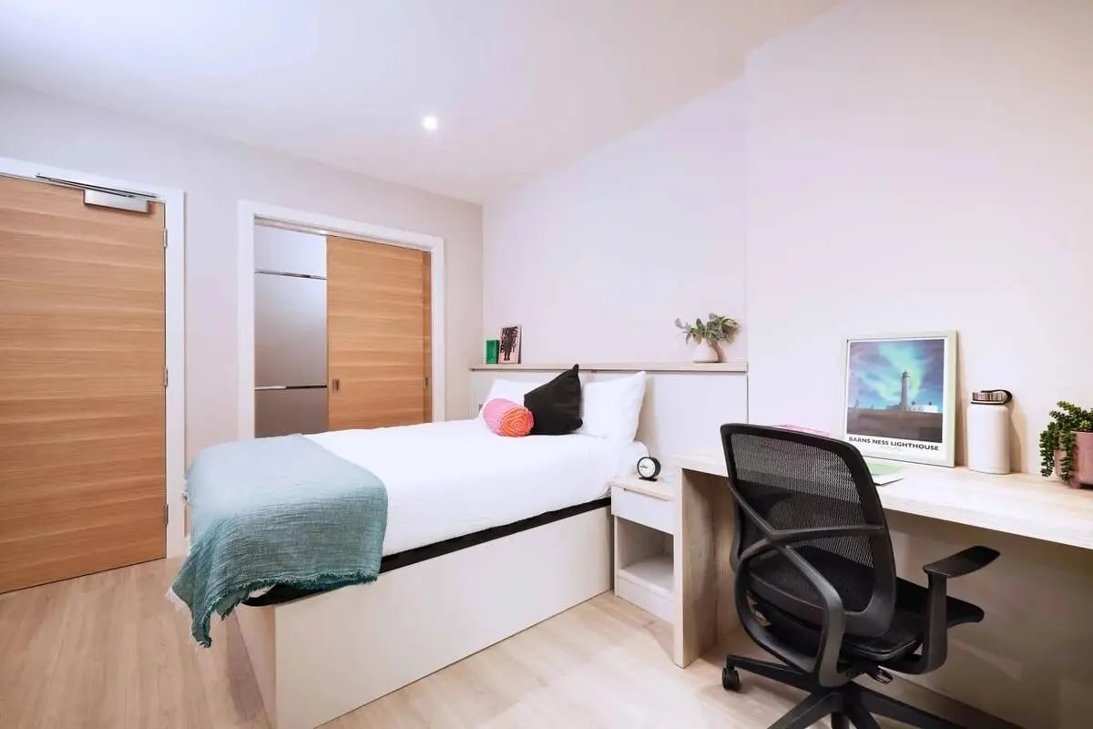 Bed desk chair and framed lighthouse print bedroom at Vita Student Iona Street in Edinburgh Student Accommodation