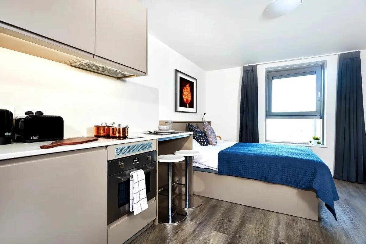 Kitchenette with bed and stools studio at Vita Student West End - Glasgow in Glasgow Student Accommodation