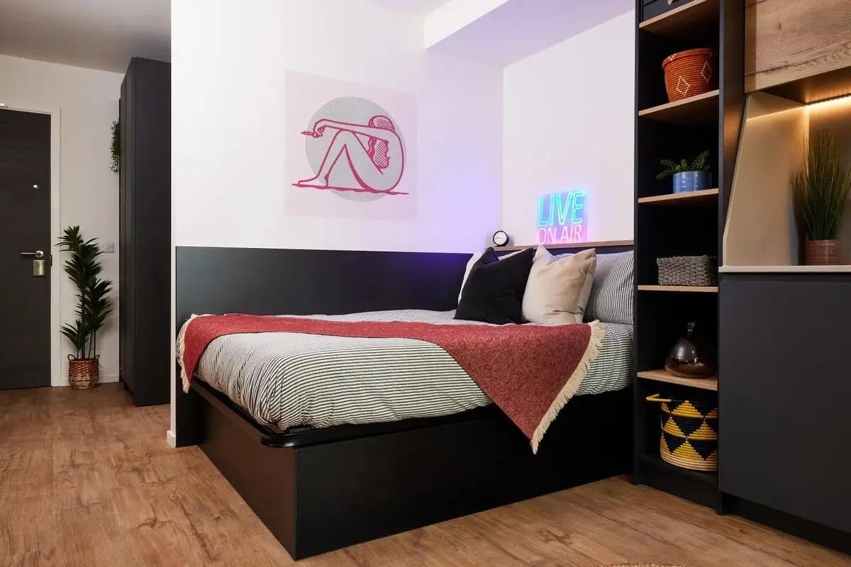 Bed with red throw art and neon sign bedroom at Vita Student Cannon Park Warwick in Coventry Student Accommodation