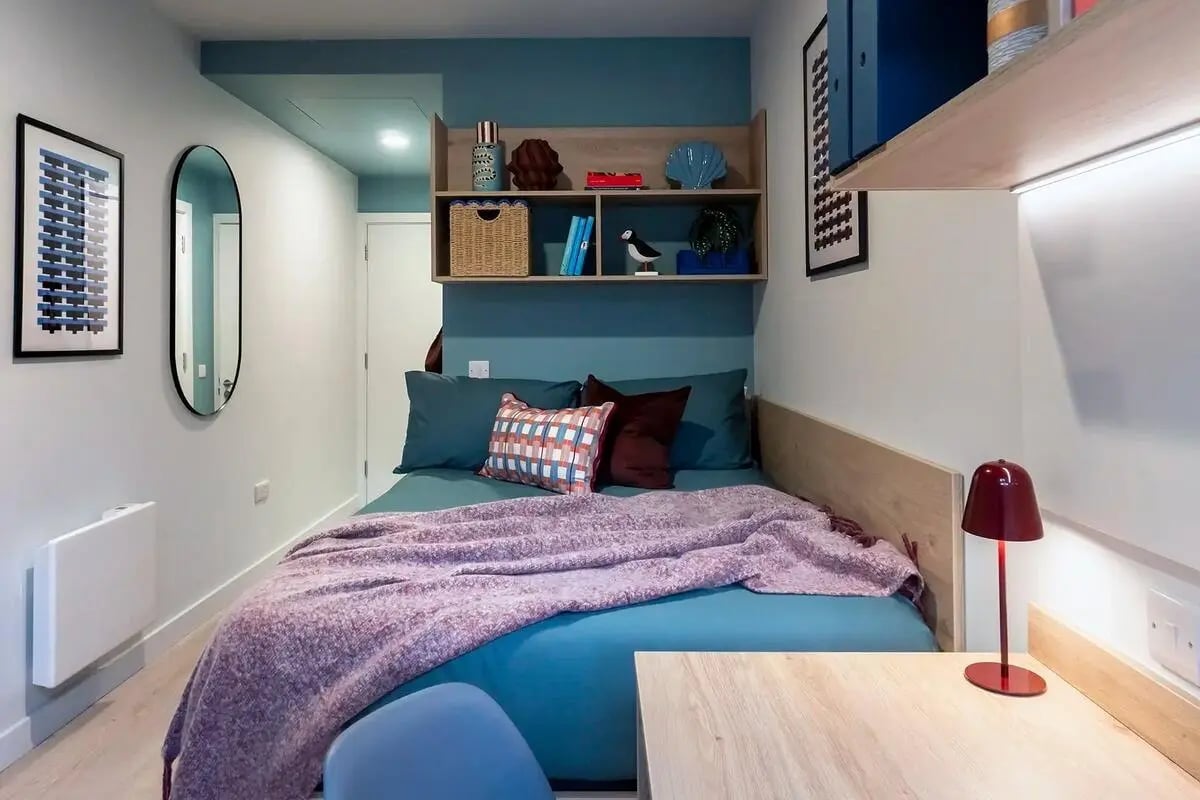 Bed with blue bedding and pink throw Bedroom at Queen Street Place in Galway Student Accommodation