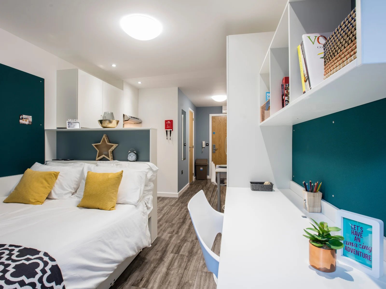 Bed yellow pillows alarm clock desk Bedroom at Botanic Studios in Belfast Student Accommodation