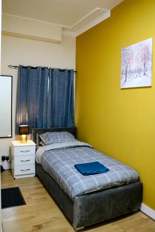 Bed nightstand lamp curtains artwork bedroom at 42 Disraeli Rd E7 9JP in London Student Accommodation