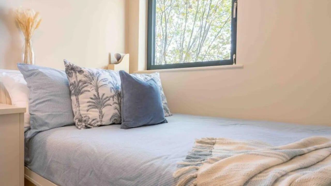Bed with pillows and throw blanket bedroom at iQ Haywood House in London Student Accommodation