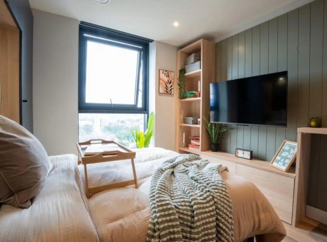 Bed with tray blanket shelves television Bedroom at Fusion Students Brent Cross in London Student Accommodation