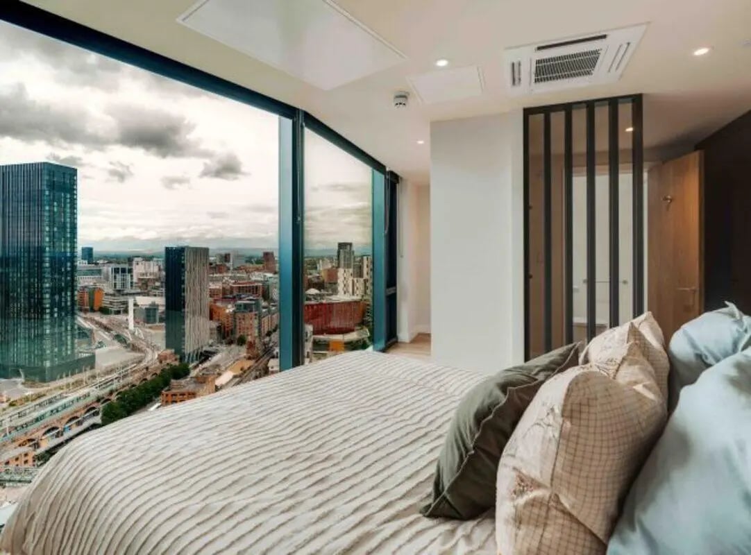 Bed with city view and pillows Bedroom at Fusion Manchester in Manchester Student Accommodation