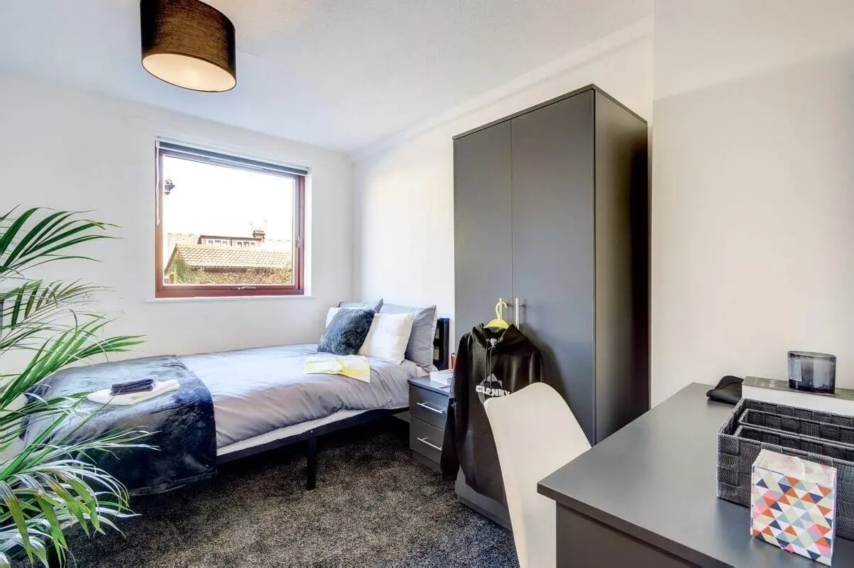 Bed wardrobe desk with plant bedroom at Clanny House in Sunderland Student Accommodation