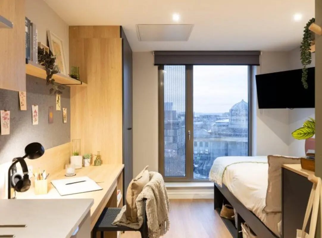 Desk lamp headphones and city view bedroom at Fusion Students Liverpool in Liverpool Student Accommodation