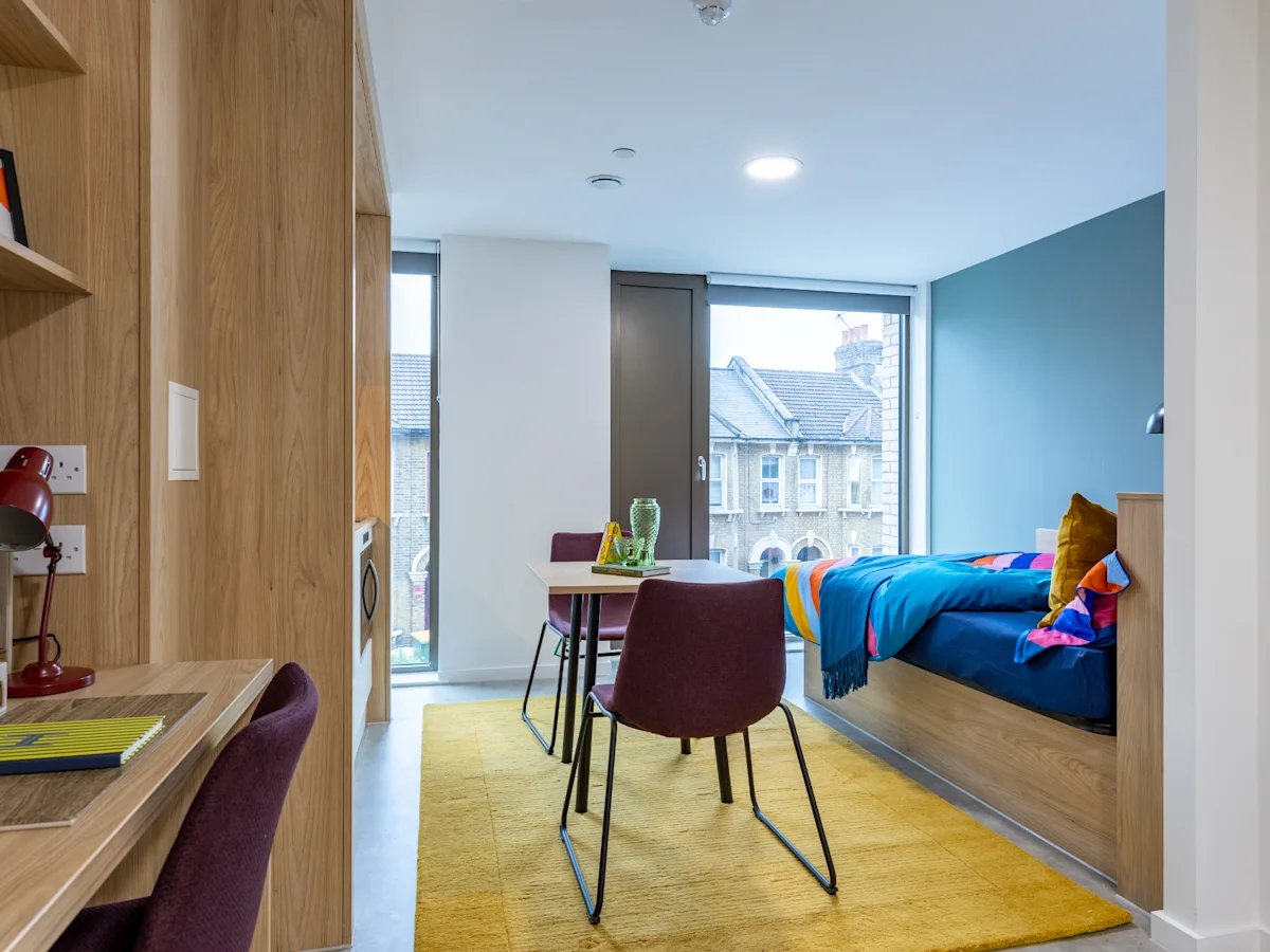 Bed desk chairs and table in room bedroom at Venti House in London Student Accommodation