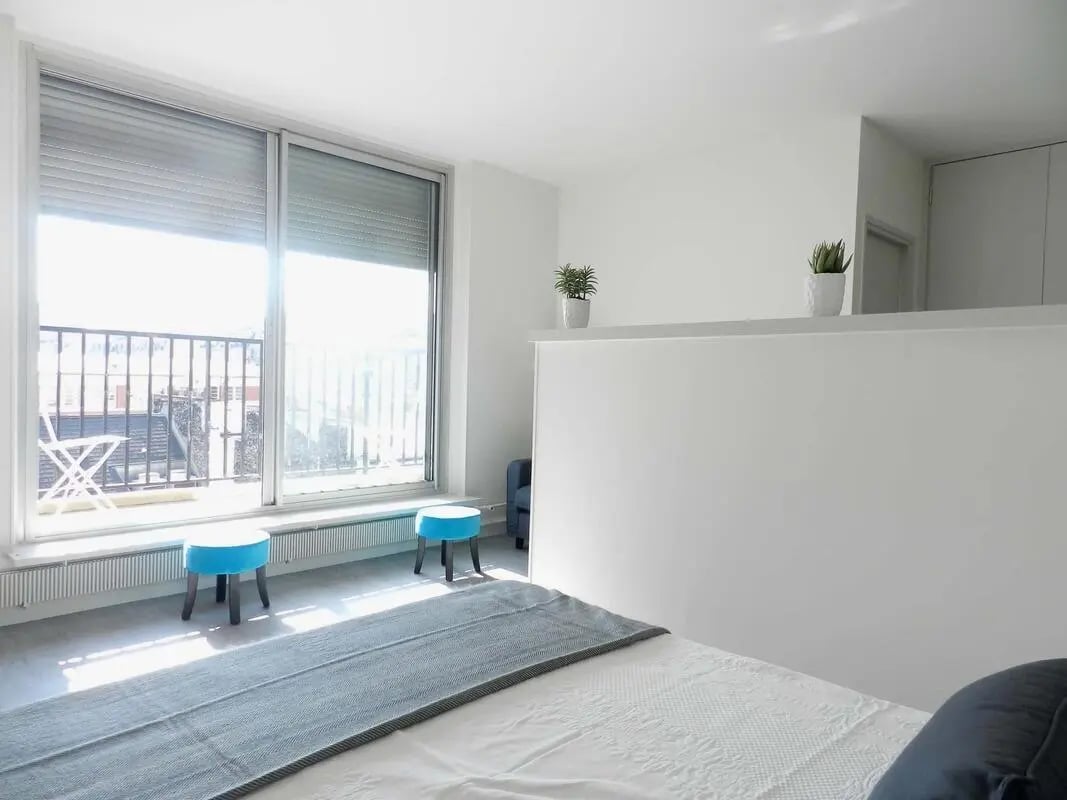 Blue stools bed plants balcony bedroom at Studio in Rue Lecourbe, 75015 Paris, France in Paris Student Accommodation