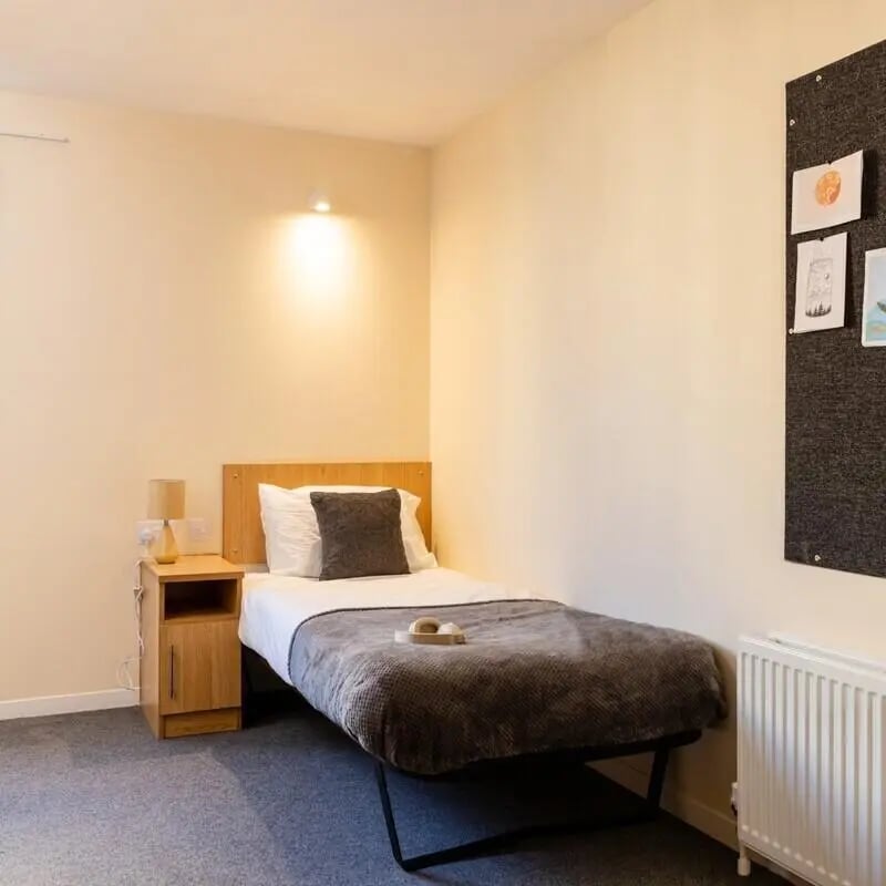 Bed bedside table lamp and noticeboard Bedroom at Bournemouth University Village - Chesil House in Bournemouth Student Accommodation