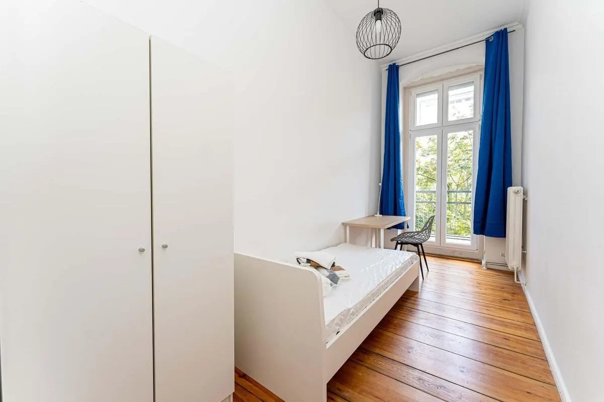 White wardrobe bed desk chair and window Bedroom at Kaiser-Friedrich-Straße - Room 4 in Berlin Student Accommodation