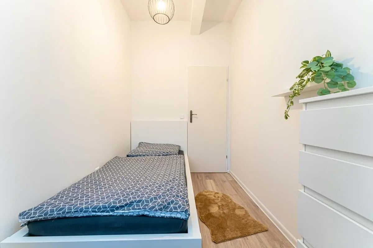 Single bed with geometric bedding and side dresser Bedroom at Sterndamm 75.2 75.3 in Berlin Student Accommodation