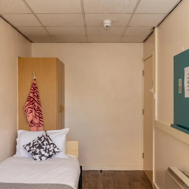 Bed wardrobe towel pillow white bedding bedroom at John Lester and Eddie Colman Courts in Salford Student Accommodation
