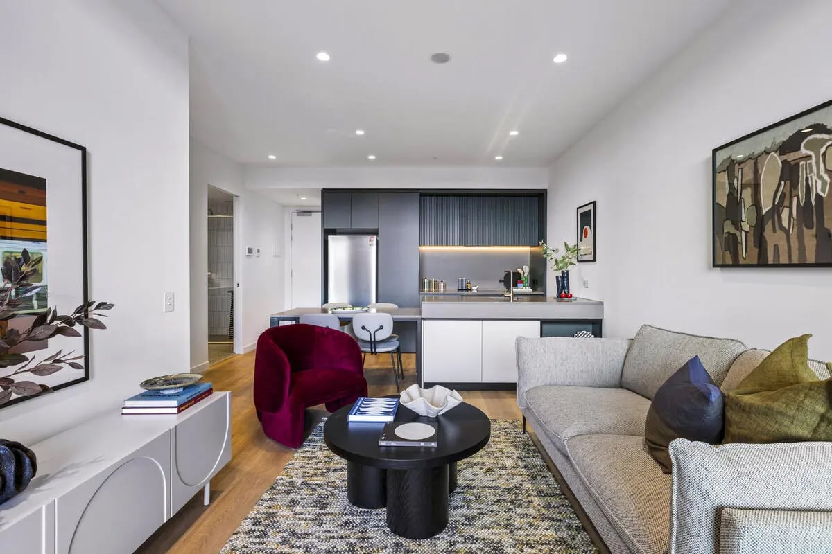 Sofa chairs table kitchen and appliances living room at Indi Footscray in Melbourne Student Accommodation