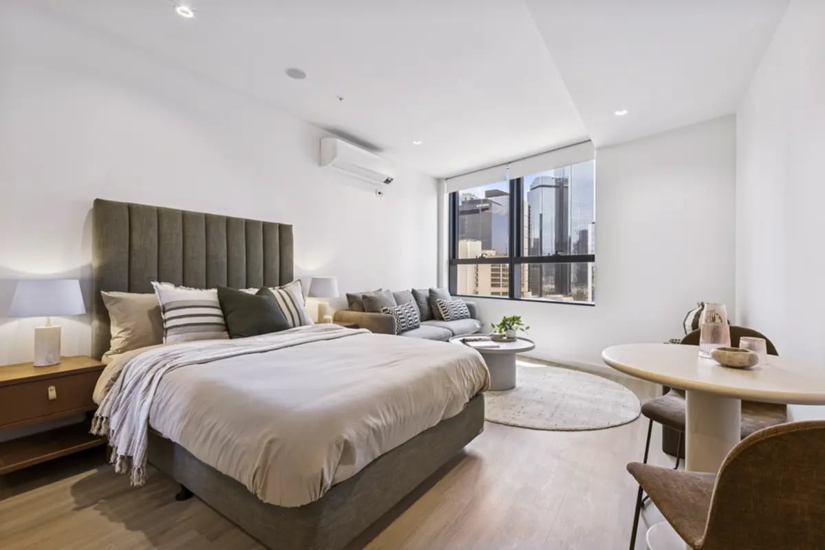 Bed sofa table with city view studio apartment at West Tower, Melbourne Quarter in Melbourne Student Accommodation