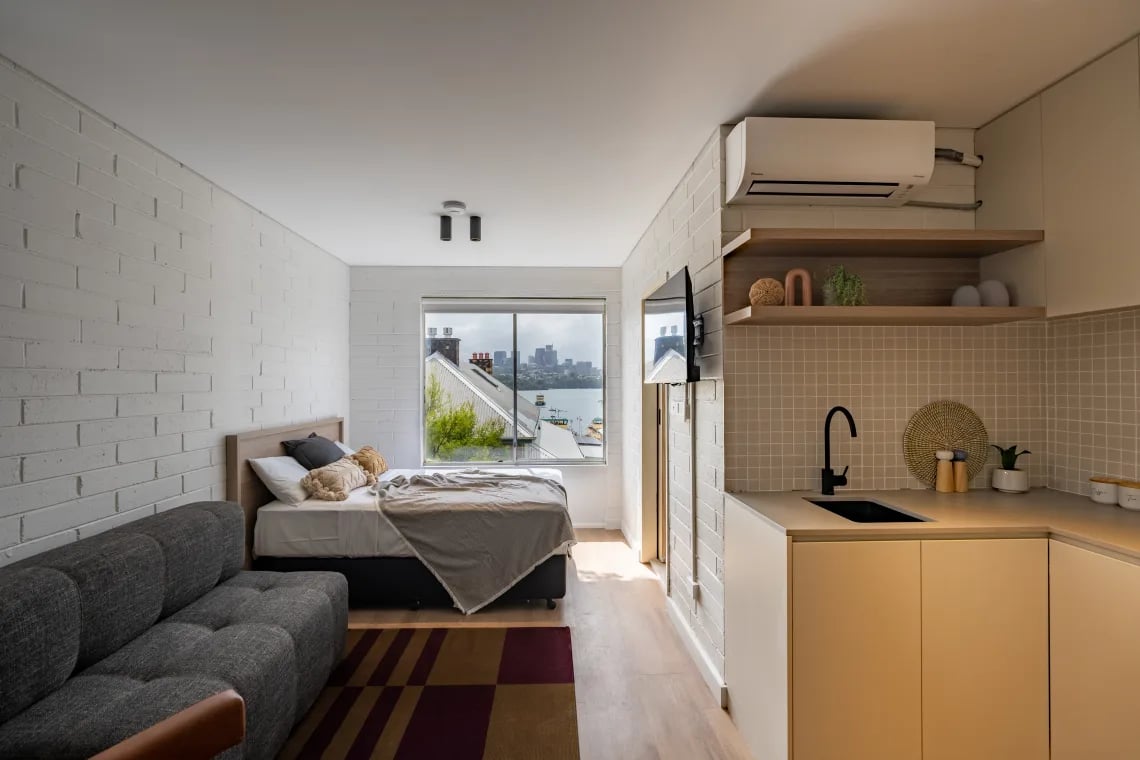 Bed sofa kitchen sink and cabinets studio apartment at UKO Balmain in Sydney Student Accommodation