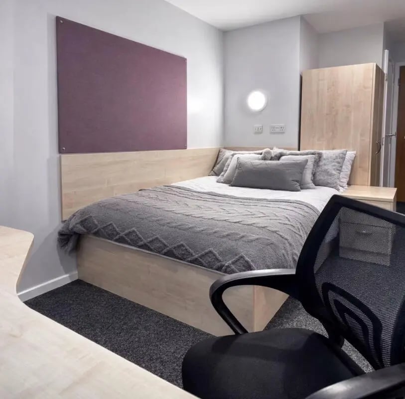 Bed with grey blanket and pillows wardrobe bedroom at Buchanan View in Glasgow Student Accommodation