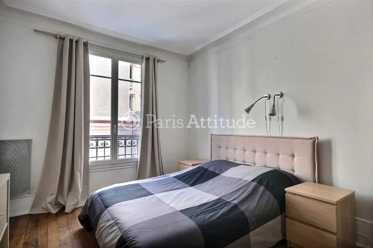 Bed with checkered duvet nightstand window bedroom at Apartment in Cité Voltaire, 75011 Paris, France in Paris Student Accommodation