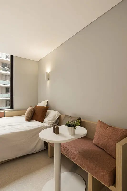 Bed, bench, table, and plant living room at Iglu Mascot Duo in Sydney Student Accommodation