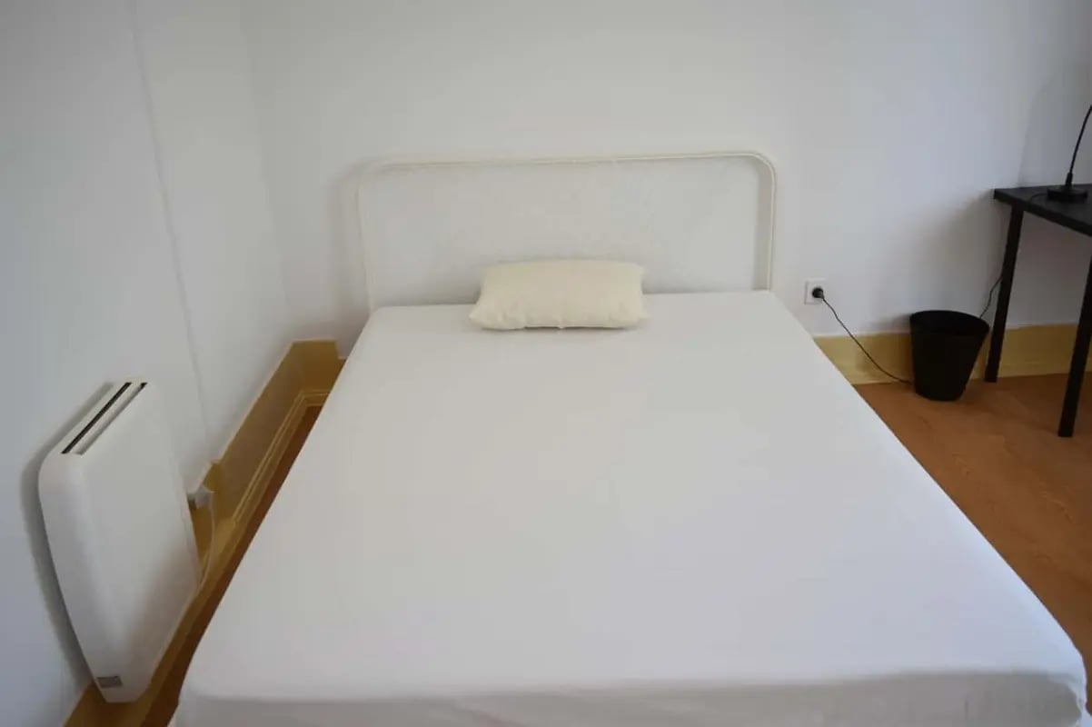 White bed with pillow radiator desk and bin bedroom at Quarto com cama de casal em apartamento com 8 quartos - FLAT G - G08 in Lisbon Student Accommodation