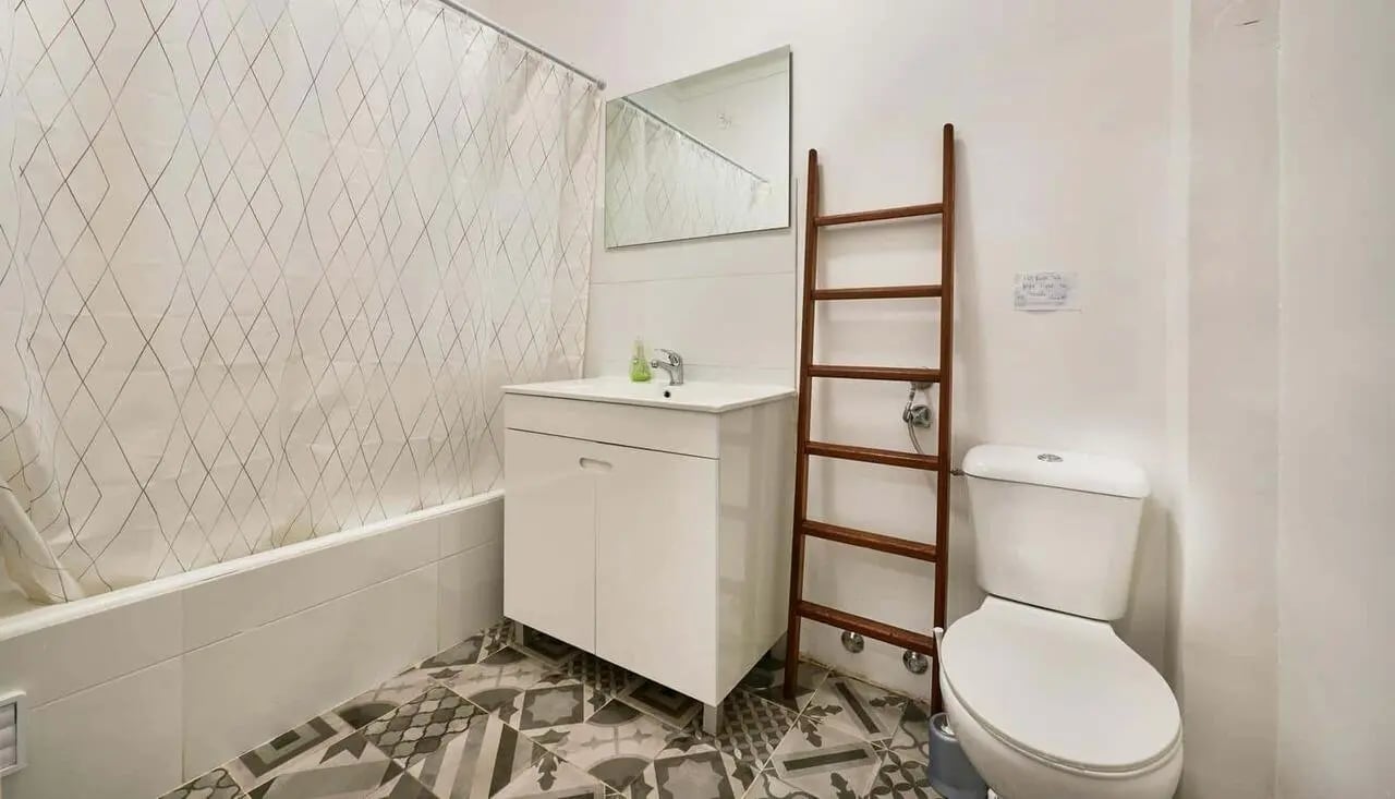 Vanity toilet ladder shower curtain bathroom at Casa Abel II – Room 5 in Lisbon Student Accommodation
