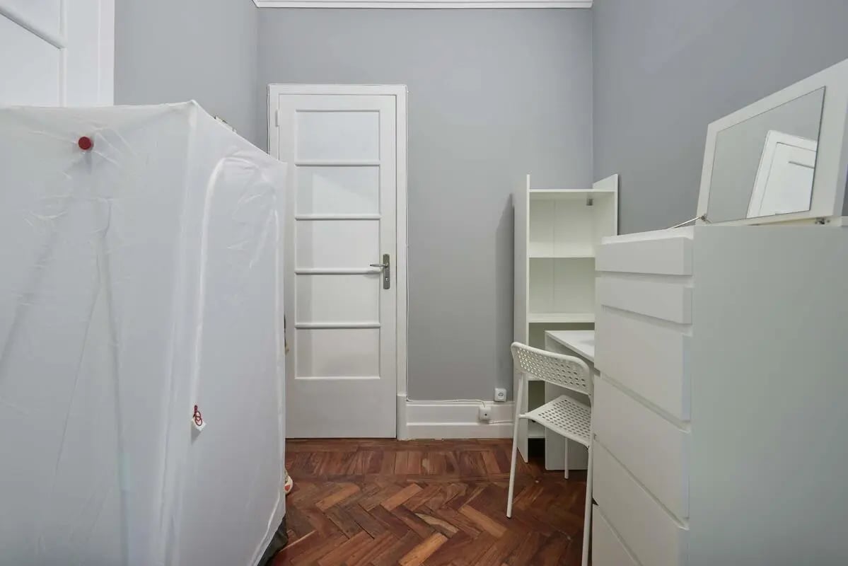 White dresser with mirror and chair study area at Casa Elias III – Room 11 in Lisbon Student Accommodation