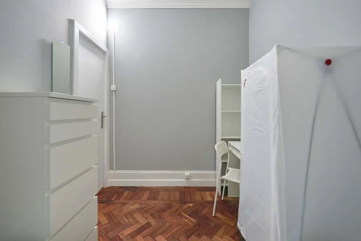 White dresser mirror door white shelf study area bedroom at Casa Elias III – Room 11 in Lisbon Student Accommodation