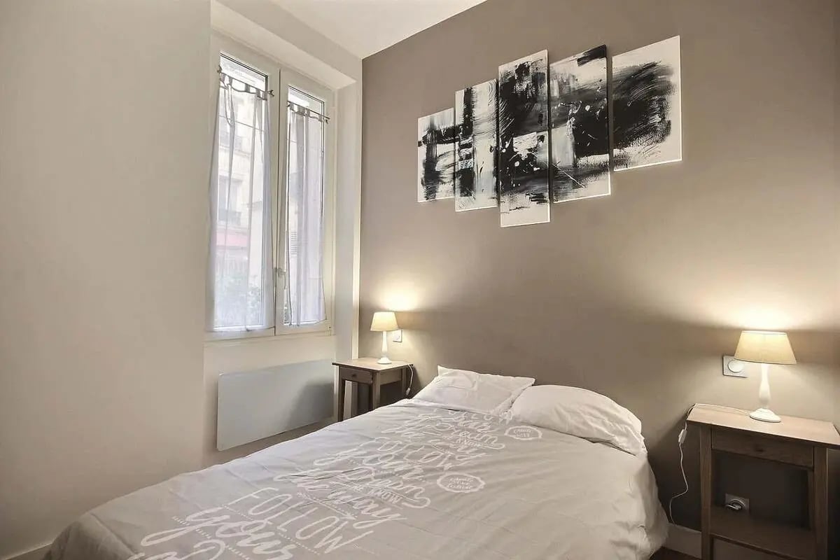 Bed with patterned duvet window and wall art bedroom at Apartment 1 bedroom 41m² in Paris Student Accommodation