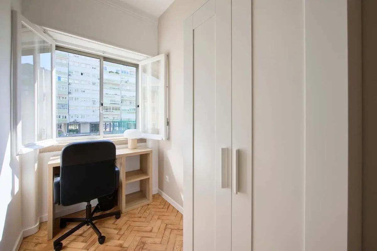 Desk chair lamp small shelf study area bedroom at Bedroom in a 10-Bedroom Apartment in Avenida Estados Unidos da América, Lisbon - Room 1 in Lisbon Student Accommodation