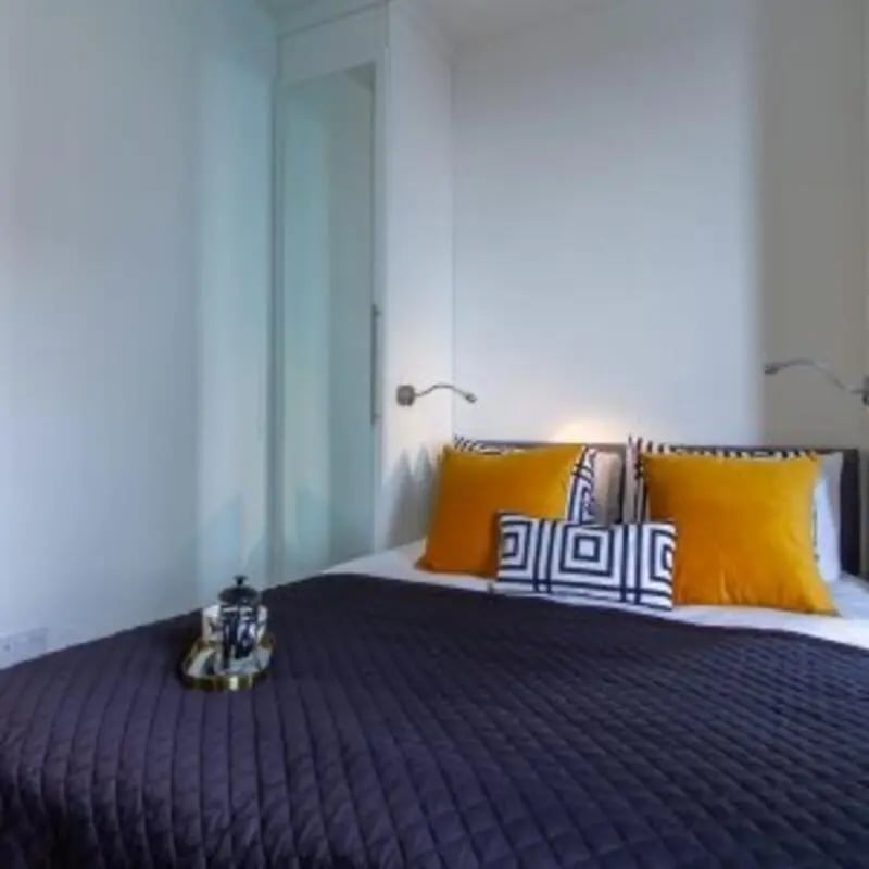 Bed with orange pillows and patterned cushions bedroom at Kensington House in Birmingham Student Accommodation