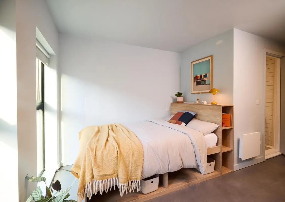 Bed with yellow throw and storage bedroom at The Store House in Leeds Student Accommodation