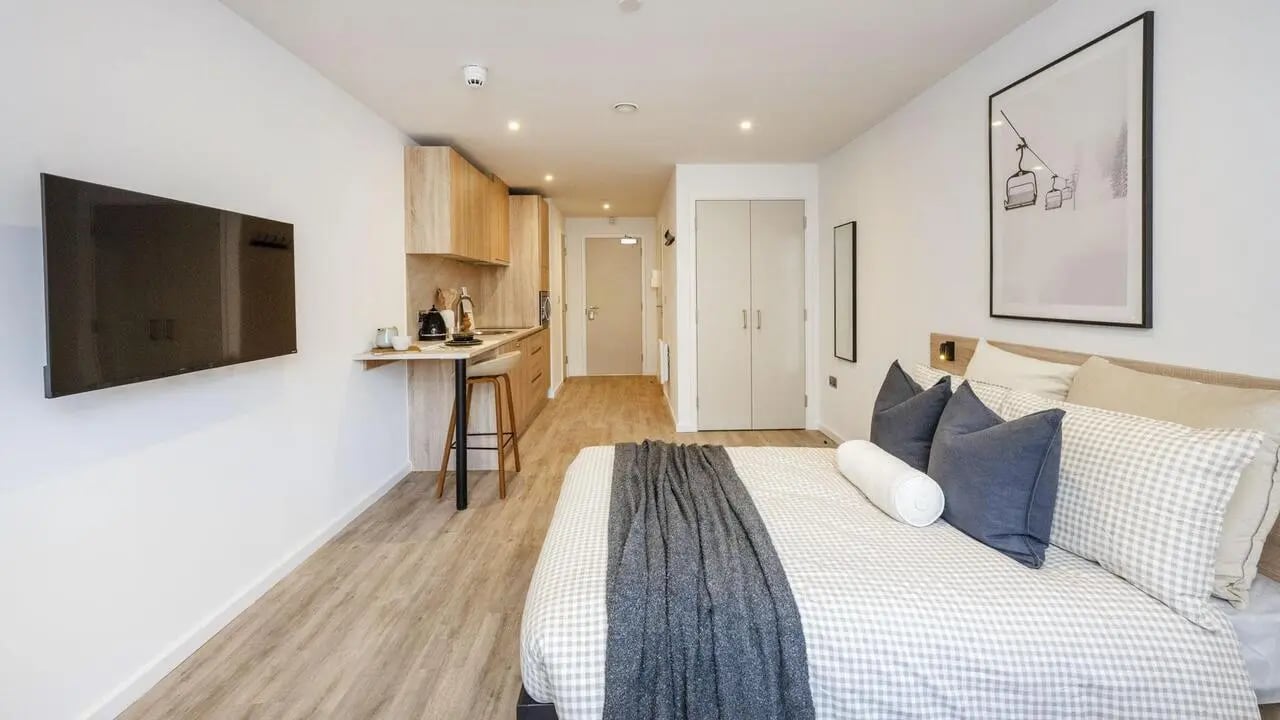 Bed TV kitchen counter and cabinets bedroom at The Fabric Works in Leeds Student Accommodation
