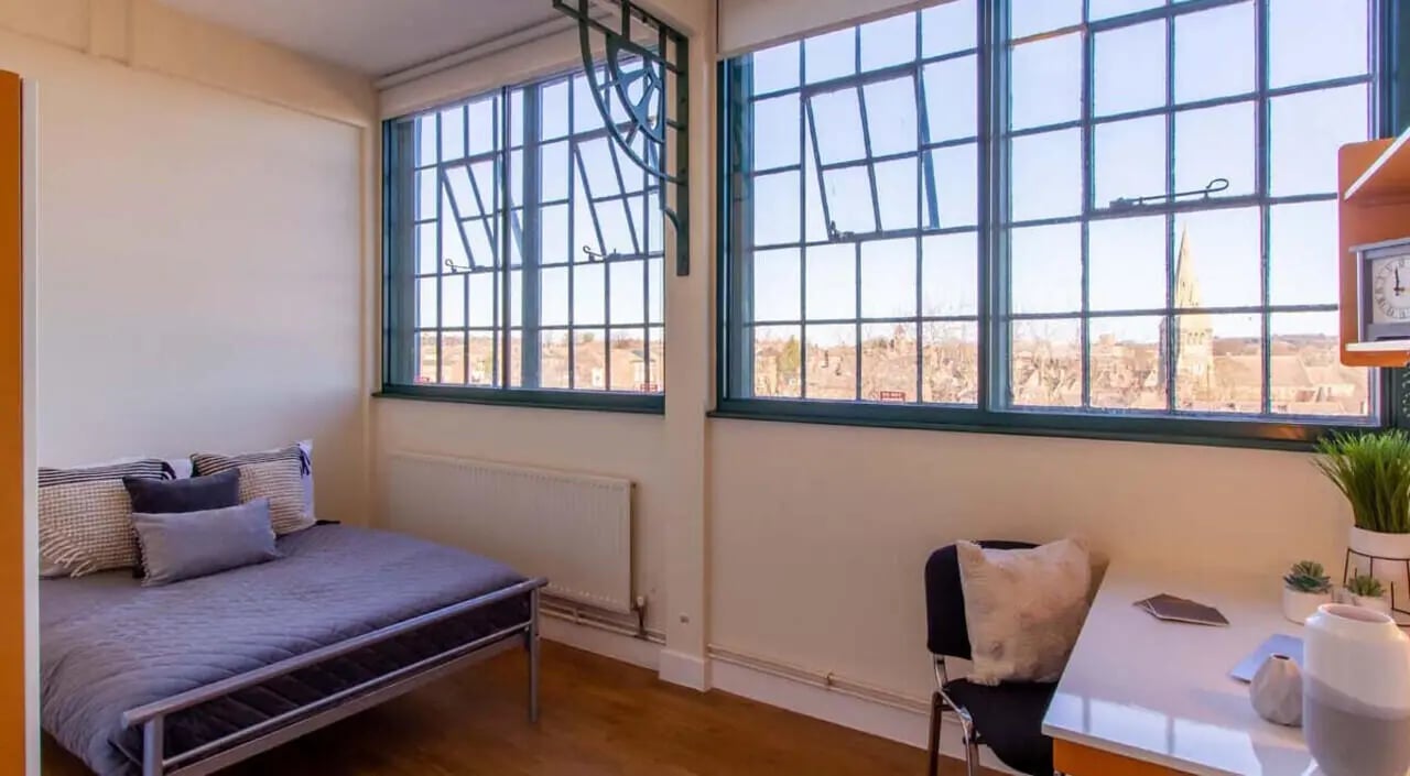 Bed desk chair and large windows bedroom at Nottingham Square in Nottingham Student Accommodation