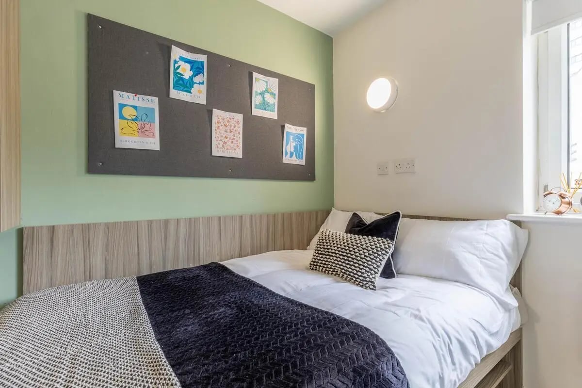 Bed with art pinboard and pillows Bedroom at Hamwic Hall in Southampton Student Accommodation