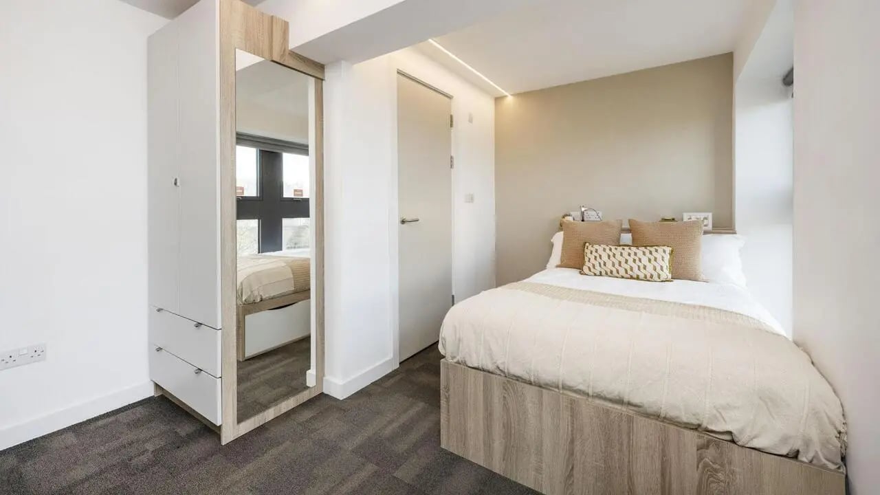 Wardrobe mirror bed with pillows bedroom at Gillows in Lancaster Student Accommodation