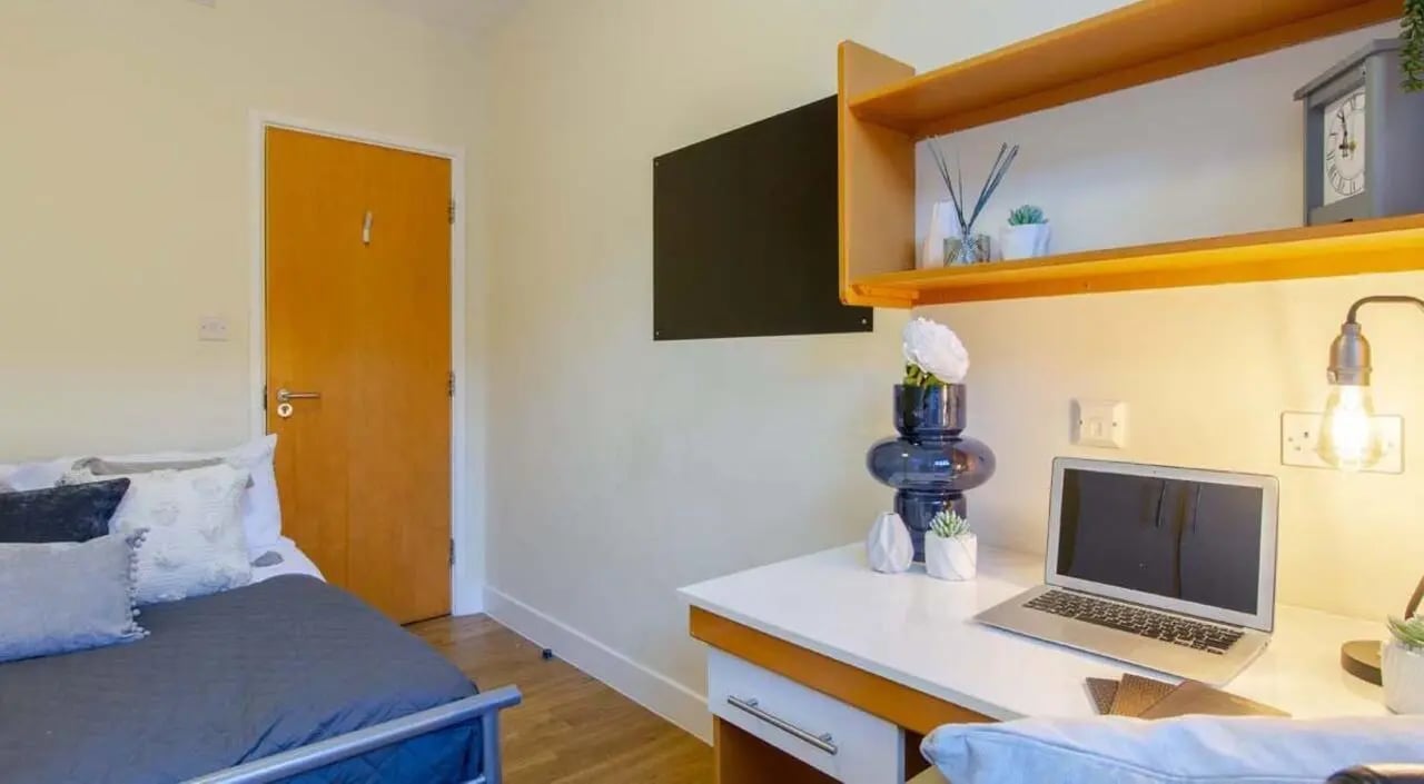Bed desk laptop and bookshelf student bedroom at Nottingham Square in Nottingham Student Accommodation