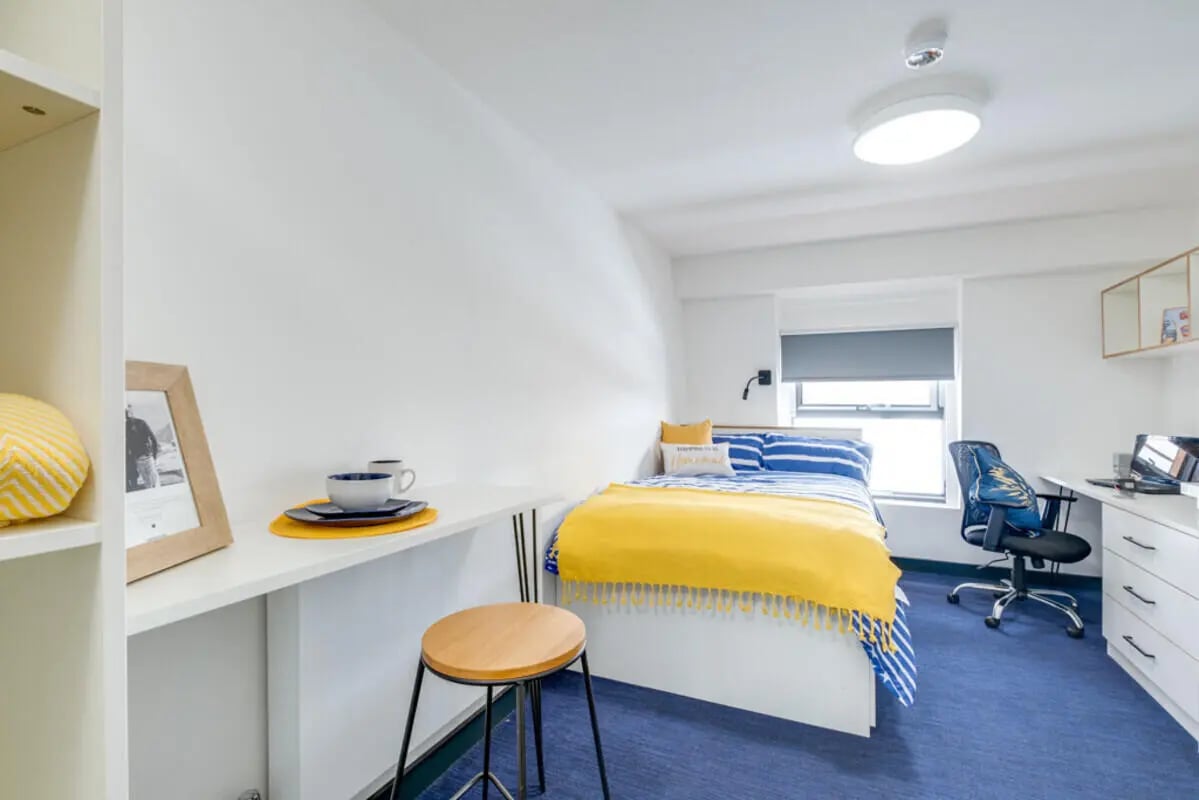 Bed desk chair shelves stool window bedroom at Fulham Palace Studios in London Student Accommodation