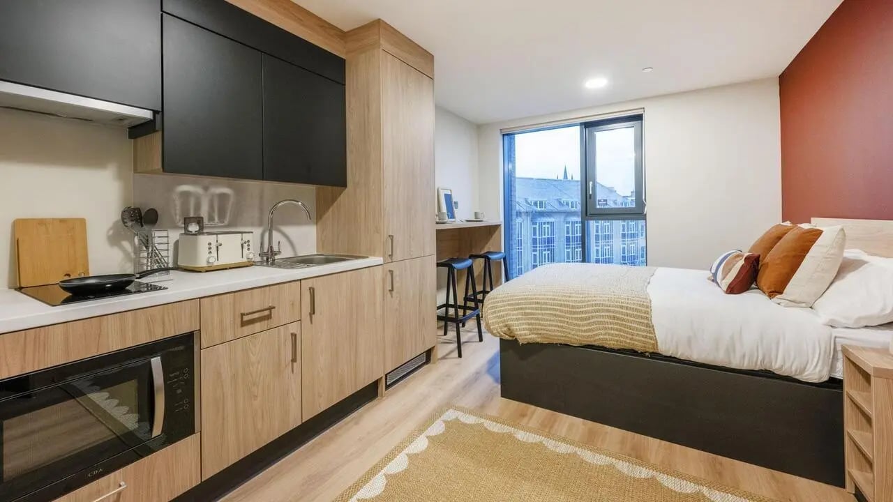 Kitchenette and bed with minimalist decor study area. at Haymarket Yards in Edinburgh Student Accommodation