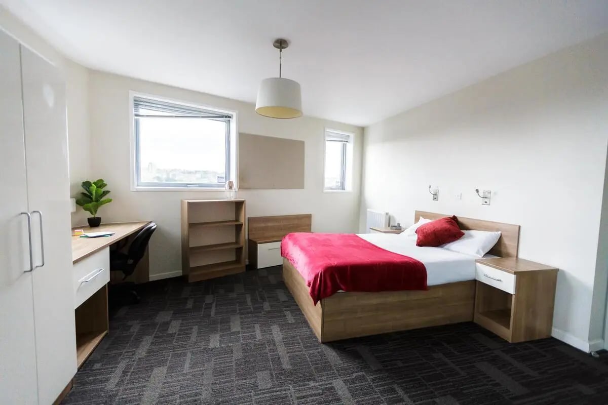Bed desk wardrobe bookshelf and windows bedroom at AXO Islington in London Student Accommodation