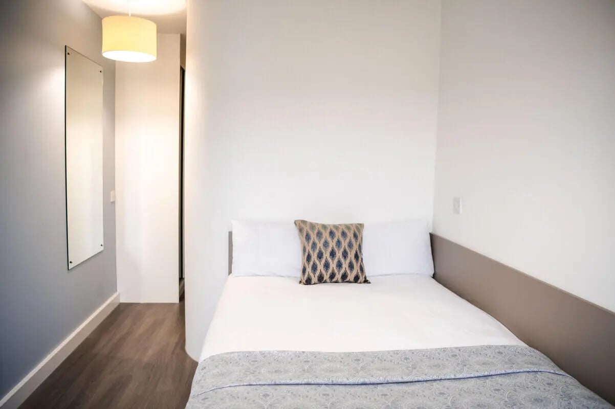 Bed with patterned pillow and blanket bedroom at McDonald Road in Edinburgh Student Accommodation